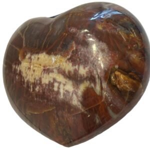 Carnelian heart 7 2 sians emporium Smooth polished carnelian carved heart palm stone with translucent amber red tones and natural circular orbicular inclusions isolated on a white background